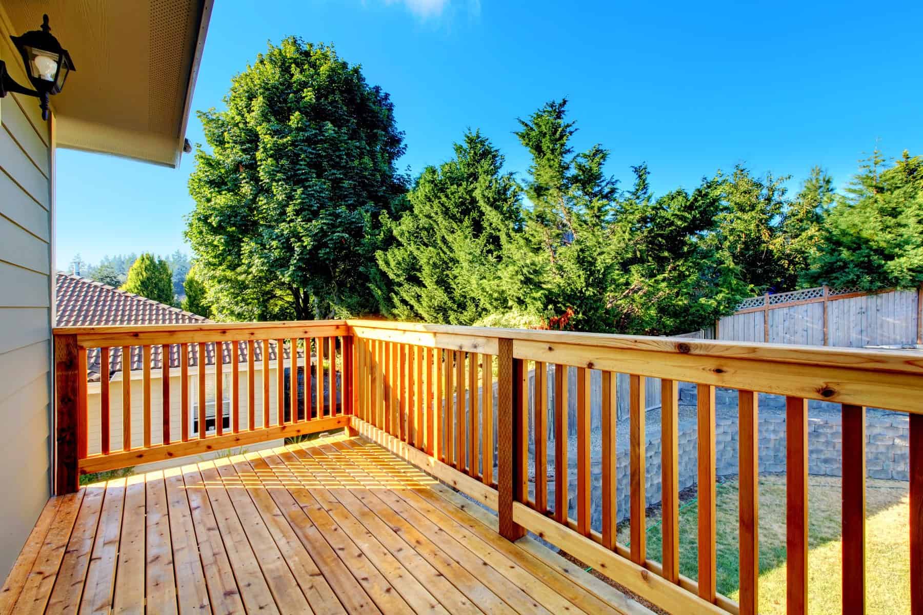 Honey Orange Stained Deck Honey-orange stained wooden deck with matching railing and spindles adjoining residential home