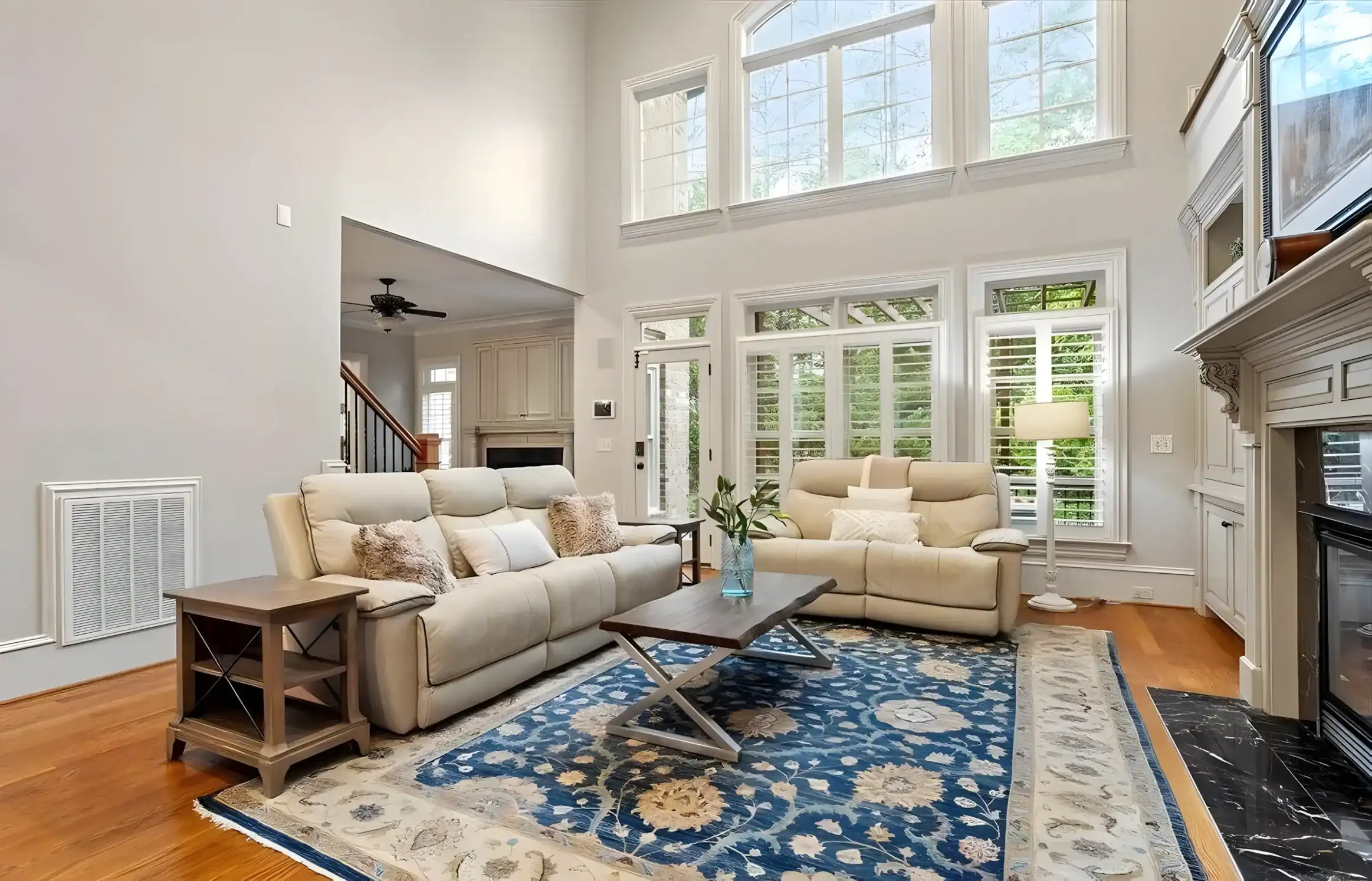 Cream Interior Residential Living Room Cream-painted residential living room with high ceilings, cream upholstered sectional sofa, hardwood floors, and large