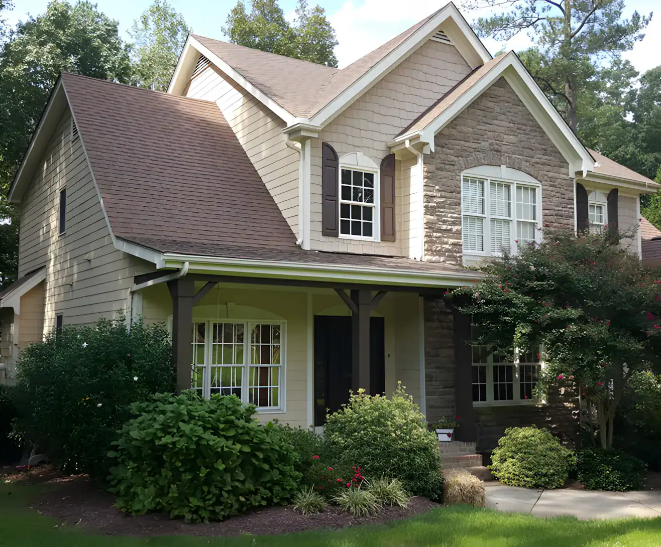 Cream And Stone Two-Story Home Exterior Cream-painted two-story residential home with stone accent siding, dark roof, white trim, and front porch in Raleigh, NC
