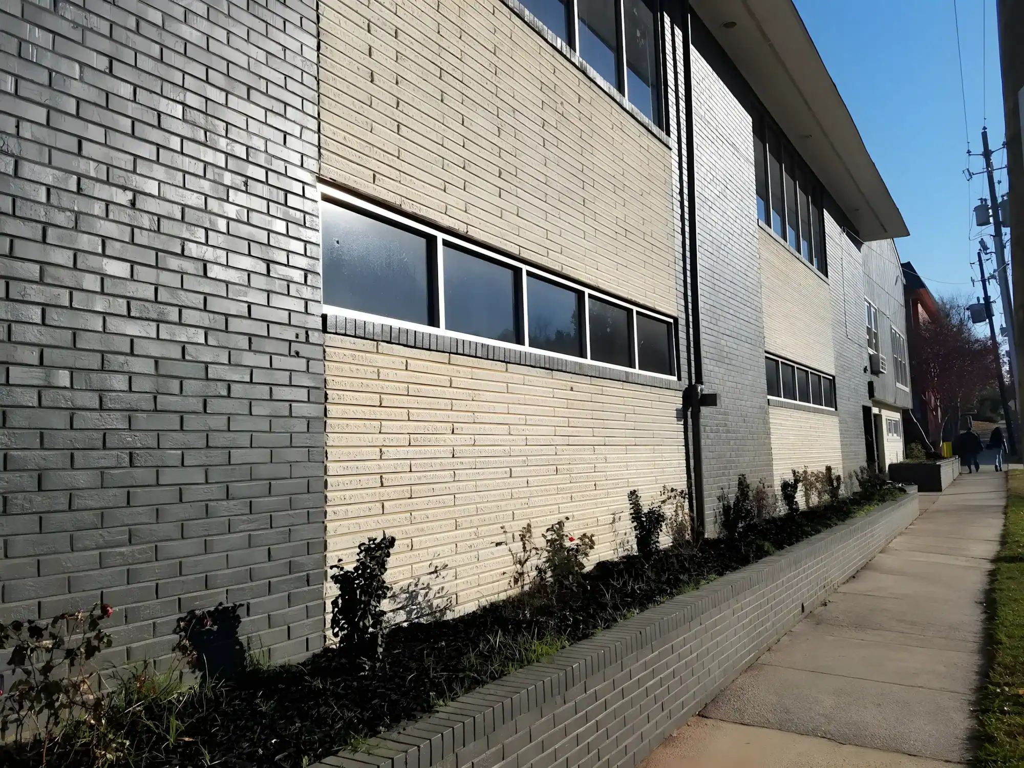 Cream Brick Residential Building Exterior Cream-painted brick residential building exterior with black-trimmed windows and foundation plantings
