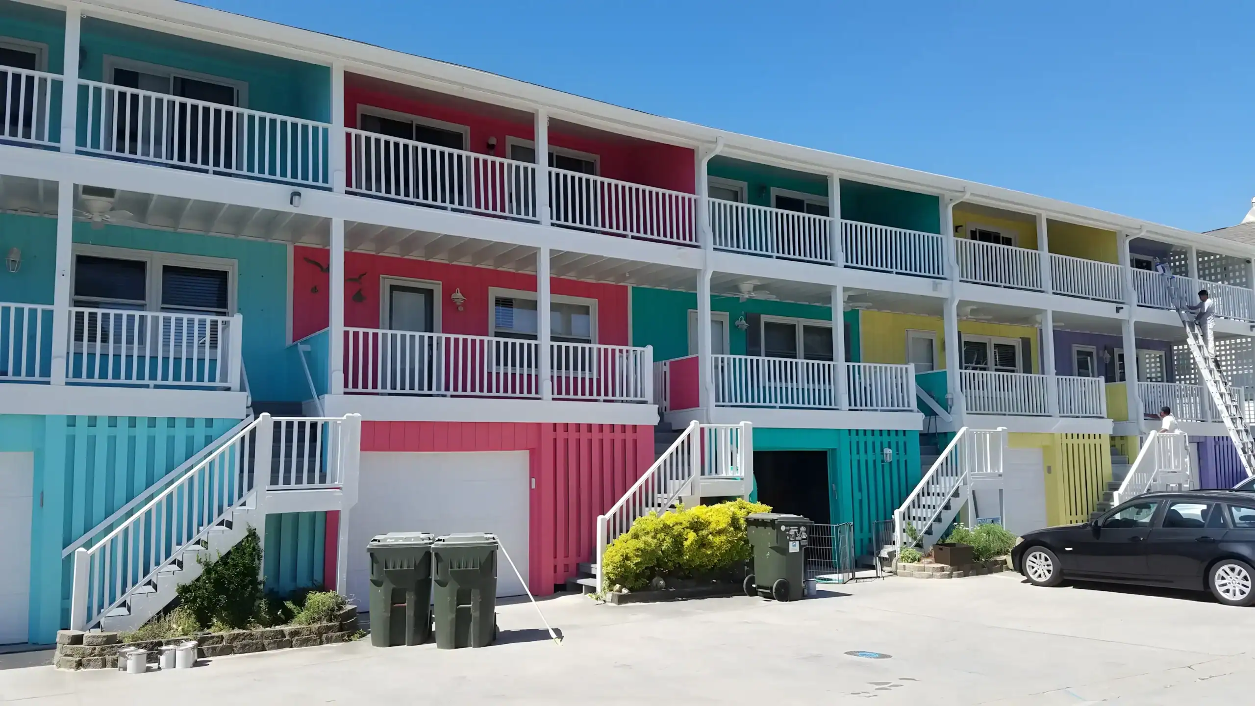 Multi-Unit Residential Building Exterior Bright multi-color residential building exterior with turquoise, red, yellow, and purple painted units and white railings