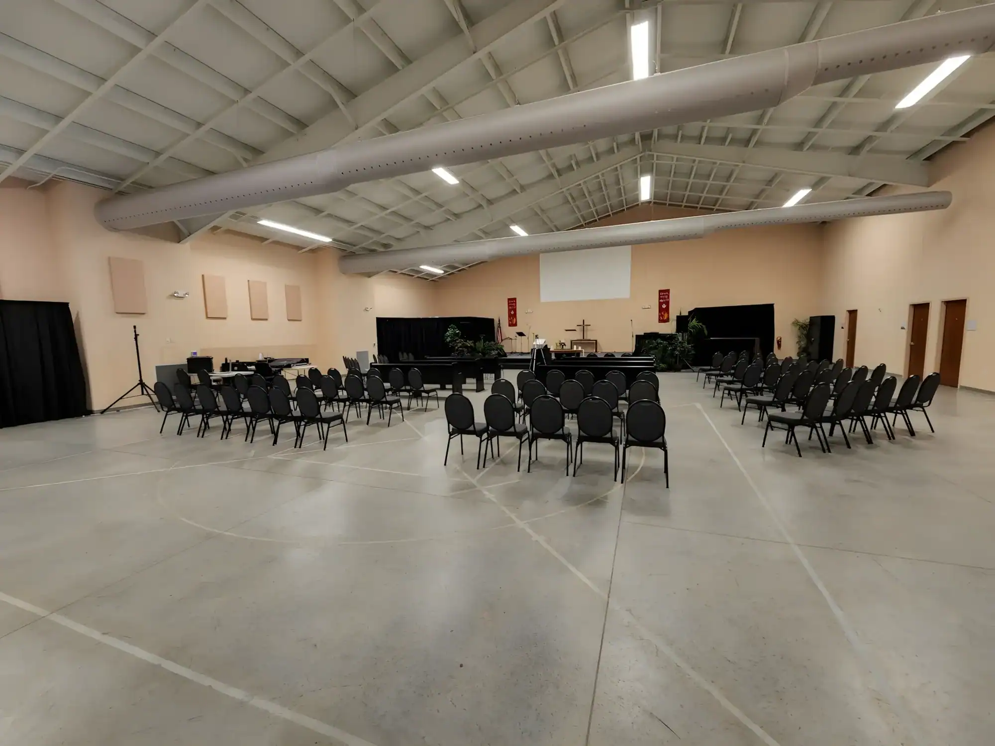 Peach Commercial Event Space Painting Peach-painted commercial interior space with polished concrete floor, exposed ductwork ceiling, and black seating