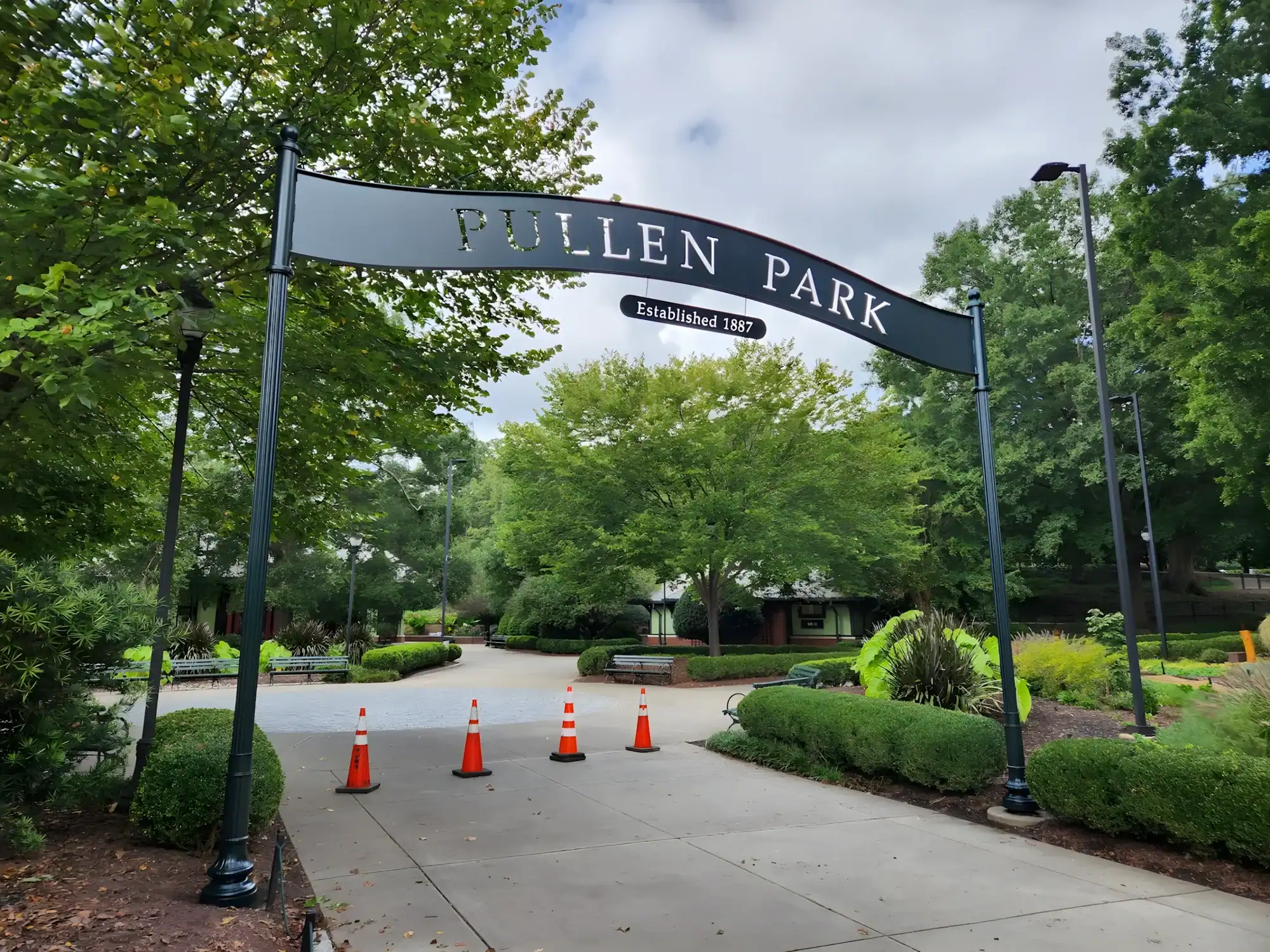 Pollen Park Entrance Sign Painting Dark navy-painted Pollen Park entrance sign with white lettering mounted on metal posts at park gateway