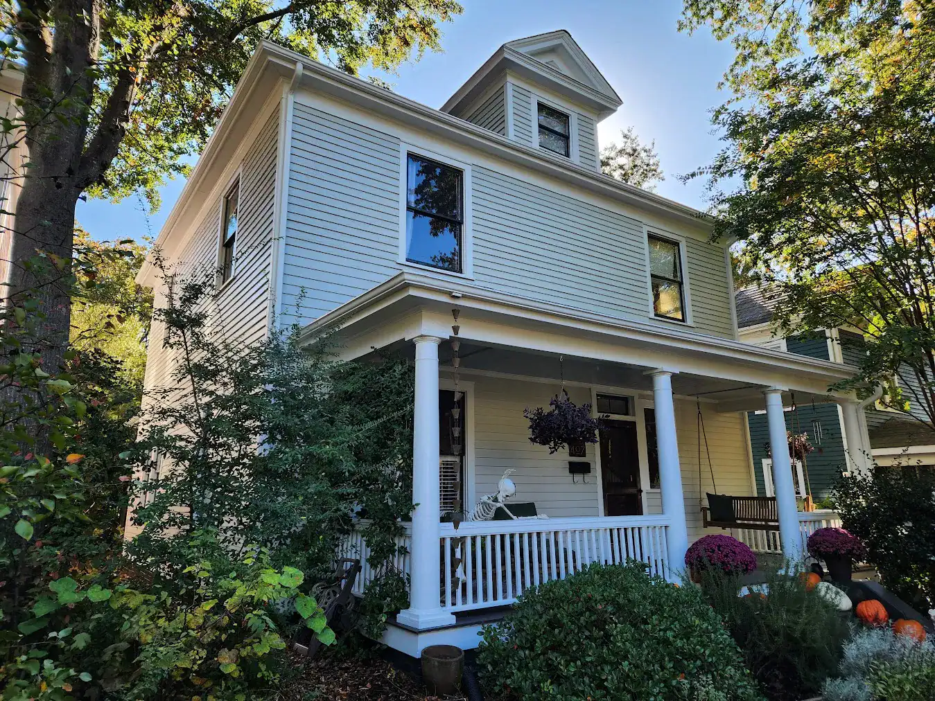 Light Blue Two-Story Residential Home Light blue horizontal-siding two-story residential home with white trim, white porch columns, railings, and gable roof in