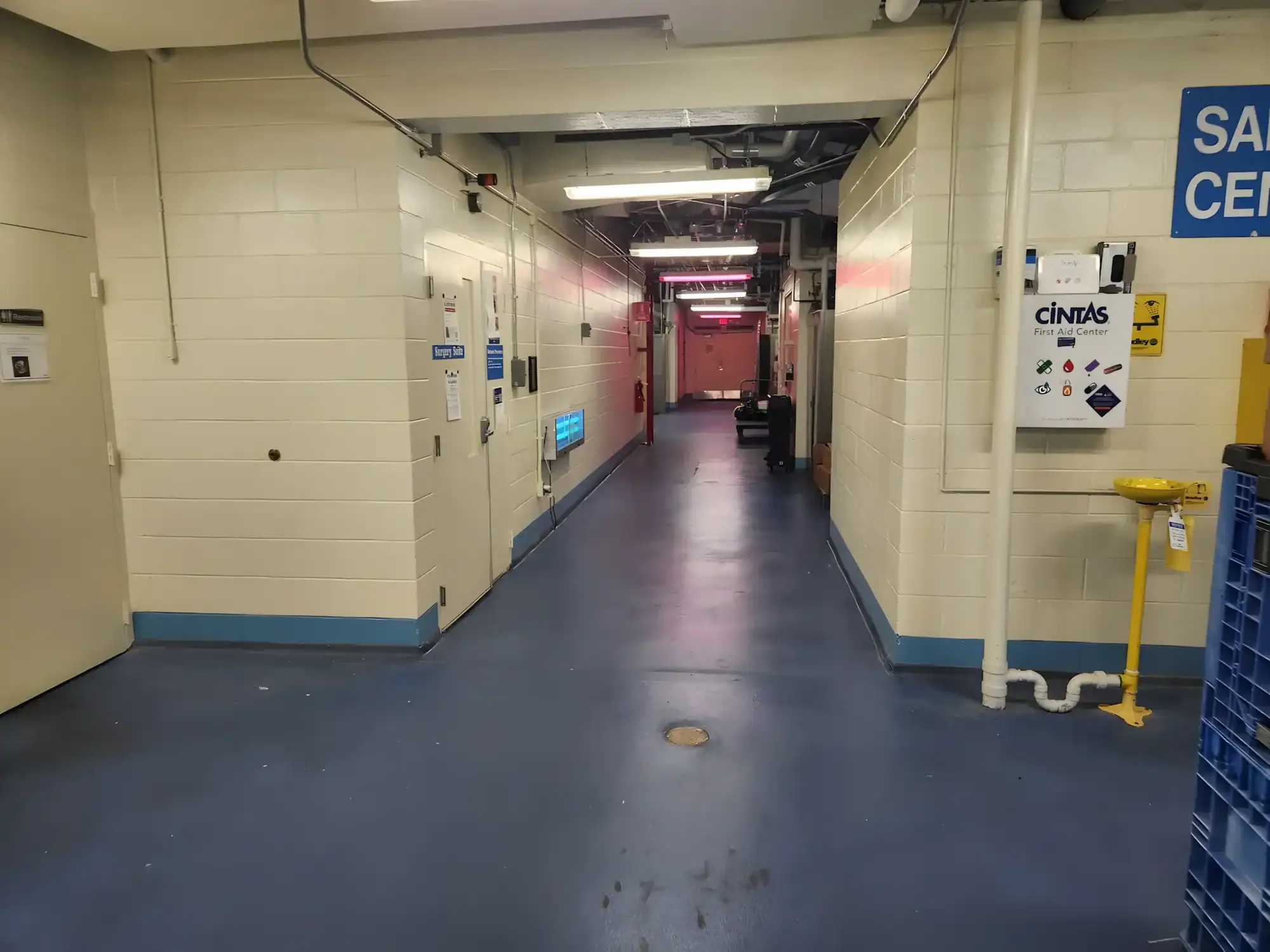 Cream And Blue Commercial Hallway Cream-painted commercial hallway with dark blue epoxy floor, blue accent stripe, and industrial ceiling lighting