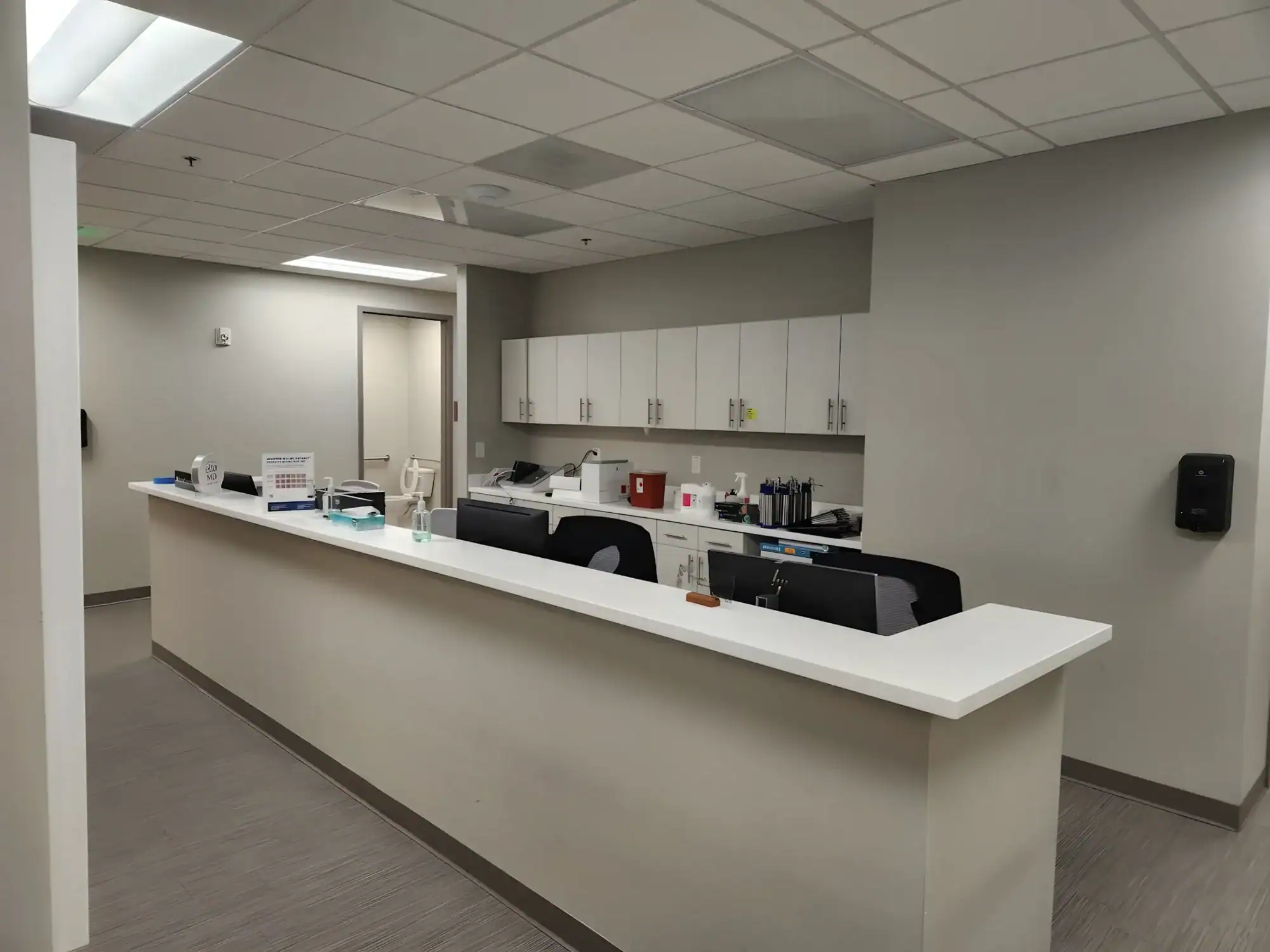 Beige Commercial Reception Area Beige-painted commercial reception area with white counter, drop ceiling, and polished concrete floor