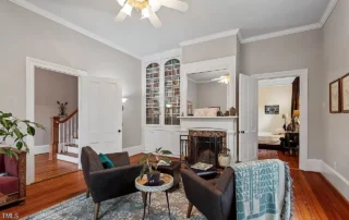 Light gray-painted two-story living room with hardwood flooring, white trim, fireplace, and dark upholstered seating how long does interior paint take to dry