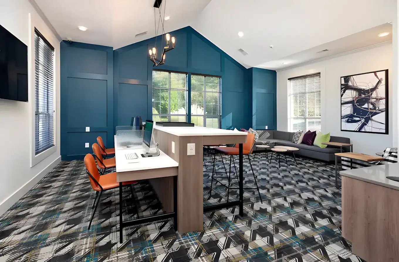 Teal Accent Wall Office Space Teal-painted commercial office interior with white ceiling, recessed lighting, orange seating, and patterned flooring.