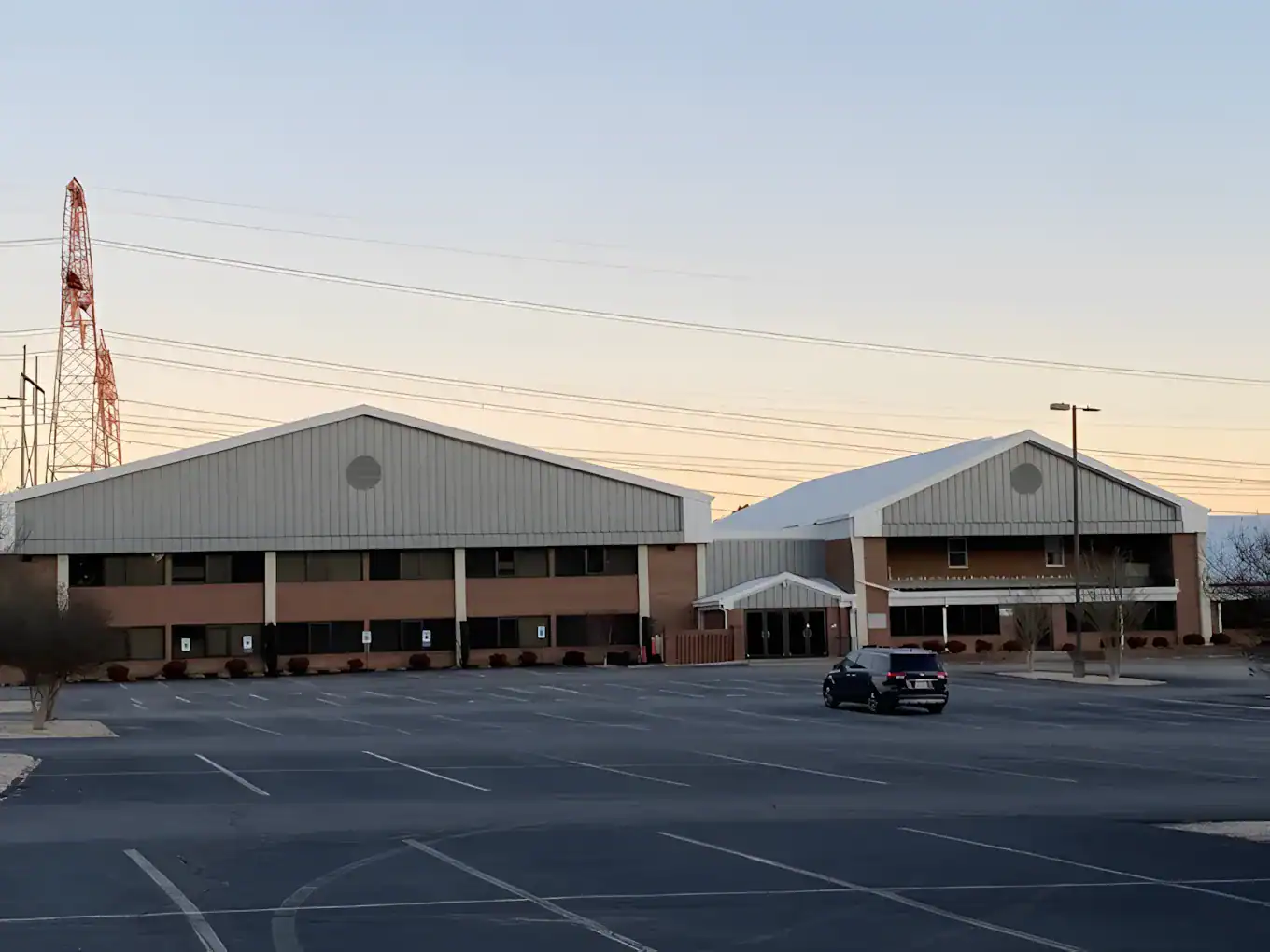 Gray Metal Roof Commercial Building Gray metal-roofed commercial building with brown brick lower facade and white support columns in parking lot